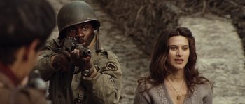 Movie still from “Miracle at St. Anna” (2008), directed by Spike Lee – A man and a woman are standing next to each other holding guns; Close Up shot, Over the shoulder angle