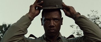 Movie still from “Miracle at St. Anna” (2008), directed by Spike Lee – A man holding a hat on top of his head; Close Up shot, Low angle