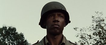 Movie still from “Miracle at St. Anna” (2008), directed by Spike Lee – A man wearing a military helmet and a uniform; Close Up shot, Low angle