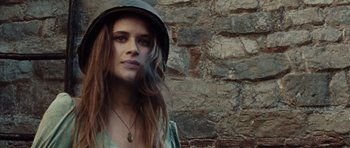 Movie still from “Miracle at St. Anna” (2008), directed by Spike Lee – A woman wearing a hat standing in front of a stone wall; Close Up shot, Low angle