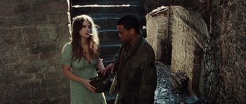 Movie still from “Miracle at St. Anna” (2008), directed by Spike Lee – A man and a woman standing next to each other in front of some steps; Medium shot, Over the shoulder angle