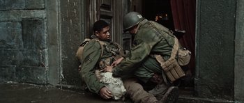 Movie still from “Miracle at St. Anna” (2008), directed by Spike Lee – Two men in uniform are helping a wounded soldier; Medium shot, High angle