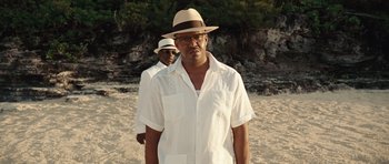 Movie still from “Miracle at St. Anna” (2008), directed by Spike Lee – A man wearing a white shirt and a hat standing next to another man wearing a white hat; Medium shot, Low angle