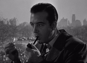 Movie still from “Miracle on 34th Street” (1947), directed by George Seaton – A black and white photo of a man smoking a pipe; Close Up shot, Low angle