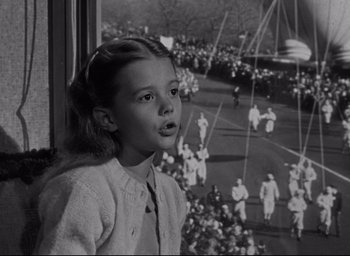 Movie still from “Miracle on 34th Street” (1947), directed by George Seaton – A young girl looking out of a window at a parade; Close Up shot, Low angle