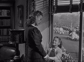 Movie still from “Miracle on 34th Street” (1947), directed by George Seaton – A woman and a girl standing next to each other in front of a window; Medium shot, Low angle