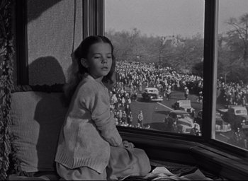 Movie still from “Miracle on 34th Street” (1947), directed by George Seaton – A little girl sitting in front of a window looking at a crowd; Medium shot, High angle