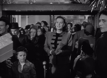 Movie still from “Miracle on 34th Street” (1947), directed by George Seaton – A woman standing in front of a group of people; Medium shot, Low angle