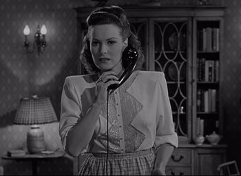 Movie still from “Miracle on 34th Street” (1947), directed by George Seaton – A black and white photo of a woman holding a phone; Medium shot, Low angle