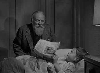 Movie still from “Miracle on 34th Street” (1947), directed by George Seaton – An old man sitting next to a little girl in a bed; Medium shot, Low angle