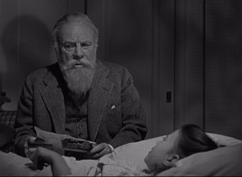 Movie still from “Miracle on 34th Street” (1947), directed by George Seaton – An older man sitting next to a young girl; Medium shot, Low angle