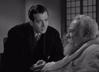 Movie still from “Miracle on 34th Street” (1947), directed by George Seaton – A man in a suit and tie talking to an older man in a bathrobe; Close Up shot, Over the shoulder angle
