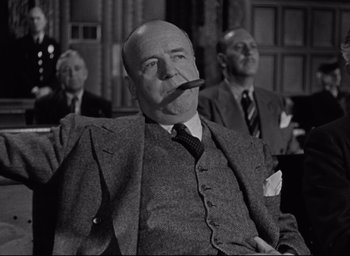 Movie still from “Miracle on 34th Street” (1947), directed by George Seaton – An old photo of a man smoking a cigarette; Medium shot, Low angle