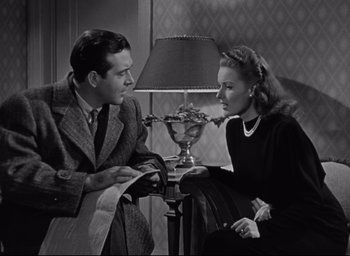 Movie still from “Miracle on 34th Street” (1947), directed by George Seaton – A man and a woman sitting next to each other in front of a lamp; Medium shot, High angle