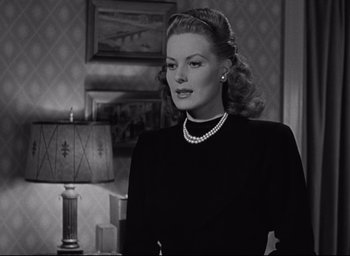 Movie still from “Miracle on 34th Street” (1947), directed by George Seaton – A black and white photo of a woman in a black dress; Close Up shot, Over the shoulder angle