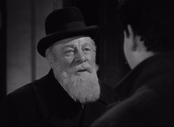 Movie still from “Miracle on 34th Street” (1947), directed by George Seaton – An old man with a beard wearing a black hat; Close Up shot, Over the shoulder angle