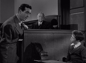Movie still from “Miracle on 34th Street” (1947), directed by George Seaton – A man in a suit and tie in front of a judge and another man in a suit and tie in front of a judge; Medium shot, Over the shoulder angle
