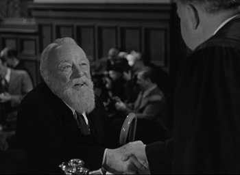 Movie still from “Miracle on 34th Street” (1947), directed by George Seaton – A man with a beard shaking hands with another man in a suit; Close Up shot, Over the shoulder angle