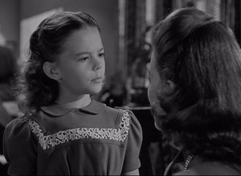 Movie still from “Miracle on 34th Street” (1947), directed by George Seaton – A young girl talking to an older woman in an old photo; Close Up shot, Over the shoulder angle
