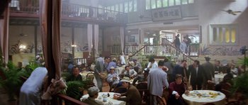 Movie still from “Miracles: The Canton Godfather” (1989), directed by Jackie Chan – A group of people sitting at tables in a restaurant; Wide shot, High angle