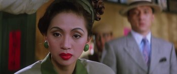 Movie still from “Miracles: The Canton Godfather” (1989), directed by Jackie Chan – A person wearing a green dress; Close Up shot, Over the shoulder angle