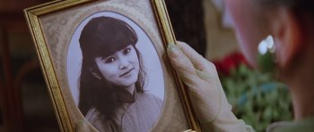 Movie still from “Miracles: The Canton Godfather” (1989), directed by Jackie Chan – A person holding a picture of a young girl; Extreme Close Up shot, High angle