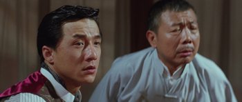 Movie still from “Miracles: The Canton Godfather” (1989), directed by Jackie Chan – Two asian men sitting next to each other in a room; Close Up shot, Low angle