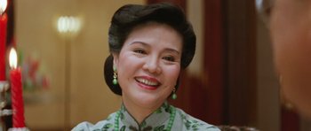 Movie still from “Miracles: The Canton Godfather” (1989), directed by Jackie Chan – An older woman wearing a dress and a necklace; Close Up shot, Low angle