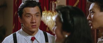Movie still from “Miracles: The Canton Godfather” (1989), directed by Jackie Chan – A man and a woman talking in front of a chandelier; Close Up shot, Over the shoulder angle