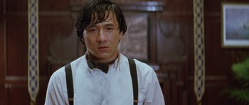 Movie still from “Miracles: The Canton Godfather” (1989), directed by Jackie Chan – A person wearing suspenders; Close Up shot, Low angle