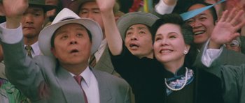 Movie still from “Miracles: The Canton Godfather” (1989), directed by Jackie Chan – A group of men and women standing next to each other; Close Up shot, Low angle