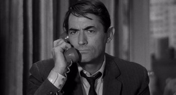 Movie still from “Mirage” (1965), directed by Edward Dmytryk – An older man talking on a phone while wearing a suit and tie; Close Up shot, High angle