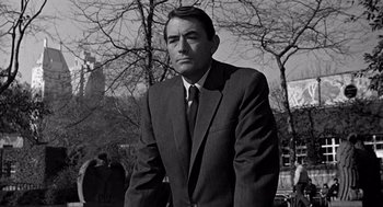 Movie still from “Mirage” (1965), directed by Edward Dmytryk – Black and white photograph of a man wearing a suit and tie; Medium shot, Low angle