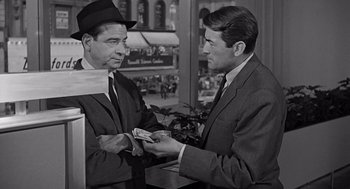 Movie still from “Mirage” (1965), directed by Edward Dmytryk – Two men in suits and hats are exchanging money; Medium shot, Over the shoulder angle