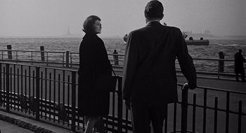 Movie still from “Mirage” (1965), directed by Edward Dmytryk – A man and a woman looking out over the water; Medium shot, Low angle