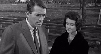 Movie still from “Mirage” (1965), directed by Edward Dmytryk – An older man and a younger woman standing next to each other; Close Up shot, Over the shoulder angle