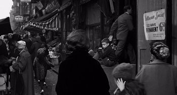 Movie still from “Mirage” (1965), directed by Edward Dmytryk – A group of people walking down a street; Wide shot, High angle