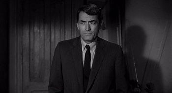 Movie still from “Mirage” (1965), directed by Edward Dmytryk – Black and white photograph of a man wearing a suit and tie; Close Up shot, Low angle