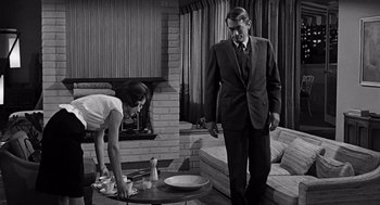 Movie still from “Mirage” (1965), directed by Edward Dmytryk – A man and a woman in a living room; Medium shot, Low angle