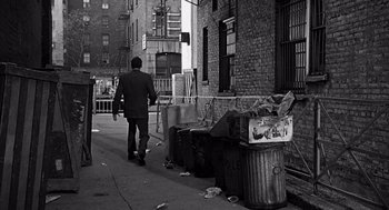 Movie still from “Mirage” (1965), directed by Edward Dmytryk – A black and white photo of a man walking down the street; Wide shot, Over the shoulder angle