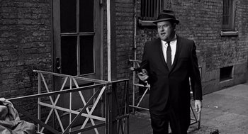 Movie still from “Mirage” (1965), directed by Edward Dmytryk – A black and white photo of a man in a suit and hat; Medium shot, Low angle