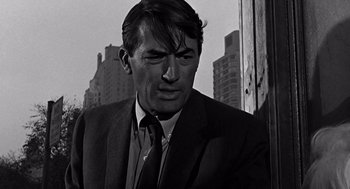 Movie still from “Mirage” (1965), directed by Edward Dmytryk – Black and white photograph of a man wearing a suit and tie; Close Up shot, Low angle