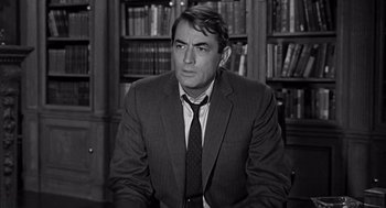 Movie still from “Mirage” (1965), directed by Edward Dmytryk – A black and white photo of a man in a suit and tie; Medium shot, Over the shoulder angle