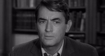 Movie still from “Mirage” (1965), directed by Edward Dmytryk – Black and white photograph of a man in a suit and necktie; Close Up shot, Over the shoulder angle
