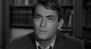 Movie still from “Mirage” (1965), directed by Edward Dmytryk – Black and white photograph of a man in a suit and tie; Close Up shot, High angle