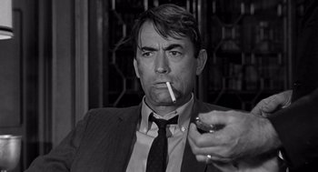 Movie still from “Mirage” (1965), directed by Edward Dmytryk – A black and white photo of a man smoking a cigarette; Close Up shot, Low angle