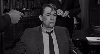 Movie still from “Mirage” (1965), directed by Edward Dmytryk – A black and white photo of a man in a suit and tie; Close Up shot, Over the shoulder angle