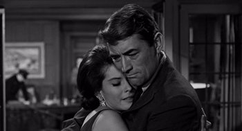 Movie still from “Mirage” (1965), directed by Edward Dmytryk – A man and a woman embracing each other in black and white; Close Up shot, Low angle