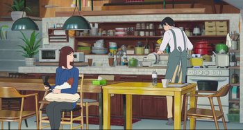Movie still from “Mirai” (2018), directed by Mamoru Hosoda – A man and a woman in a kitchen with tables and chairs; Wide shot, Over the shoulder angle