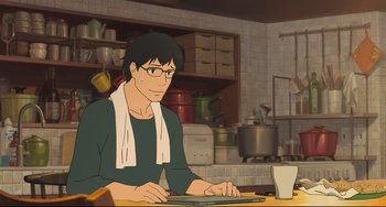 Movie still from “Mirai” (2018), directed by Mamoru Hosoda – An animated man sitting at a table with a laptop; Medium shot, High angle